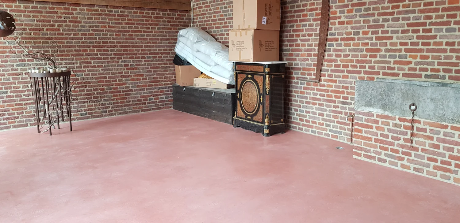 Terracottakleurige betonvloer in een hoeve in Kermt