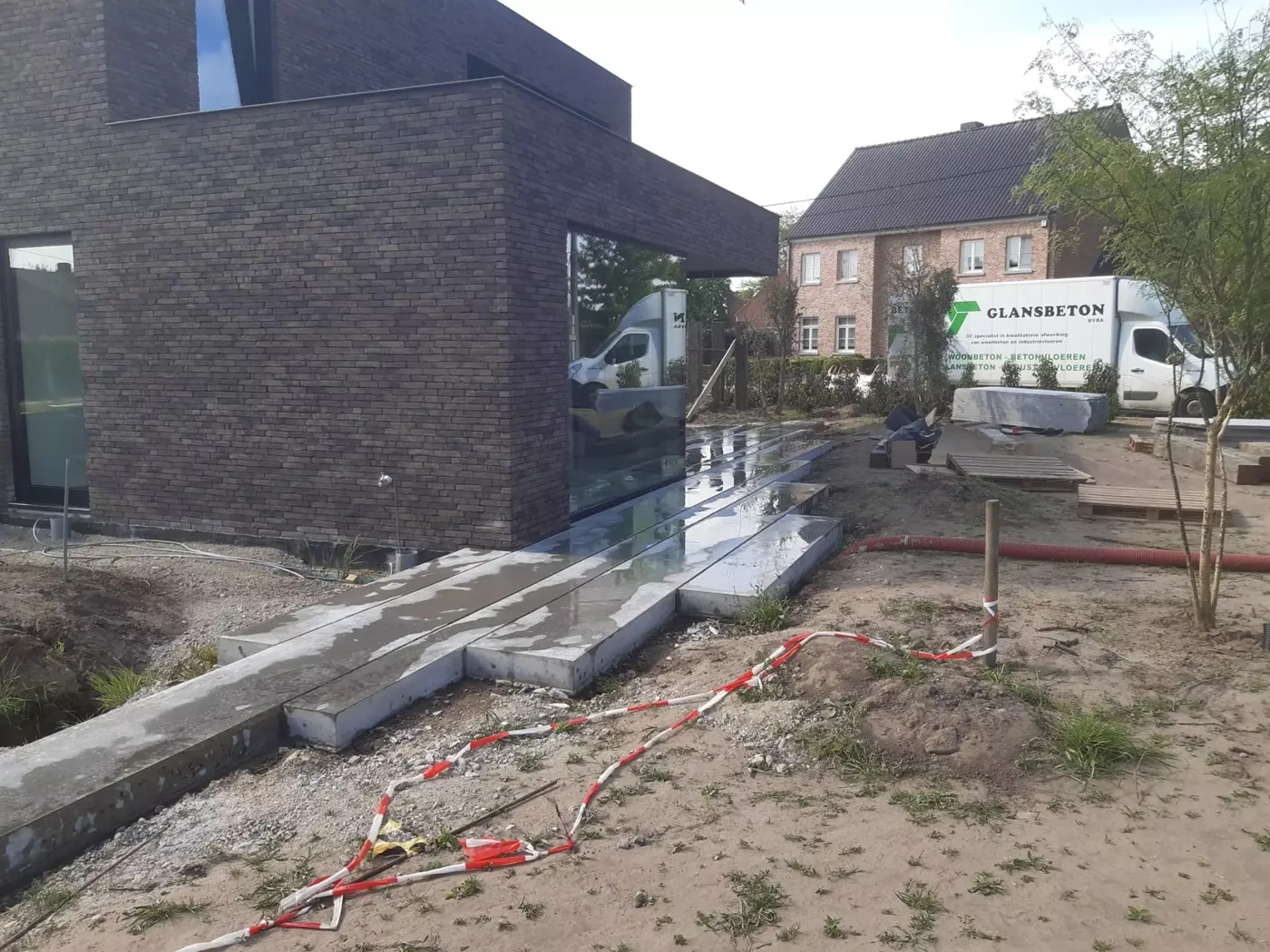 Betonwerken voor de buitenaanleg langs een moderne woning