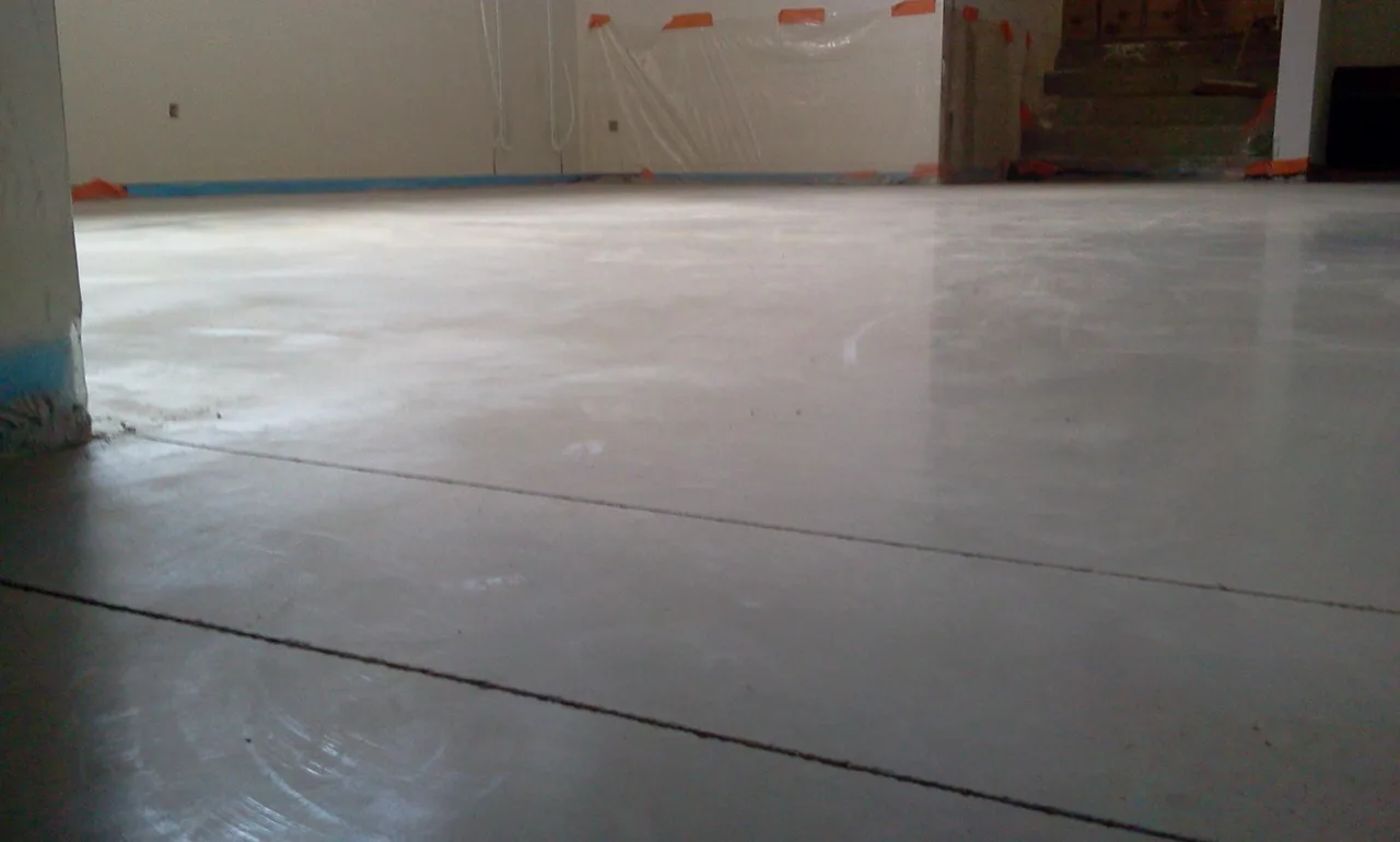 Lichte betonvloer in een woning met beschermde wanden