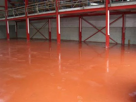 Pas afgewerkte rode betonvloer in de bedrijfshal van De Coninck
